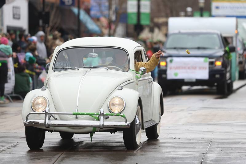 A driver throws candy to the crowds from a vintage Volkswagen Beetle at the annual Plainfield Hometown Irish Parade on Sunday, March 15, 2026 in Plainfield.