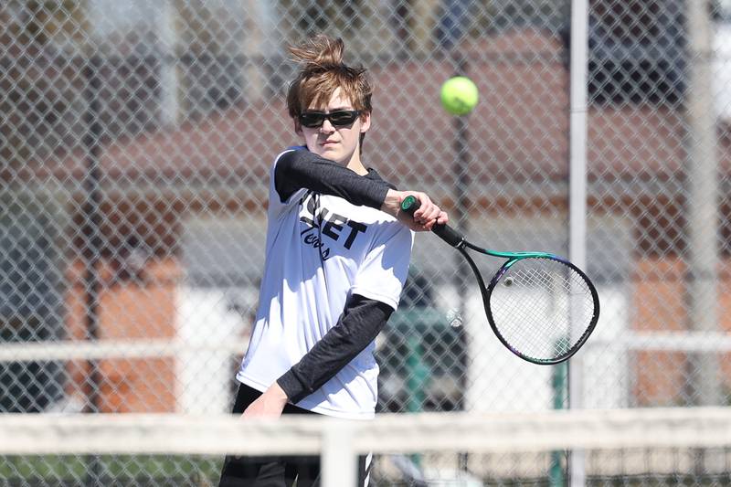 Joliet Township’s Aaron Strong returns a shot against Joliet Catholic’s Thomas Dvorak on Saturday, April 6, 2024 in Joliet.
