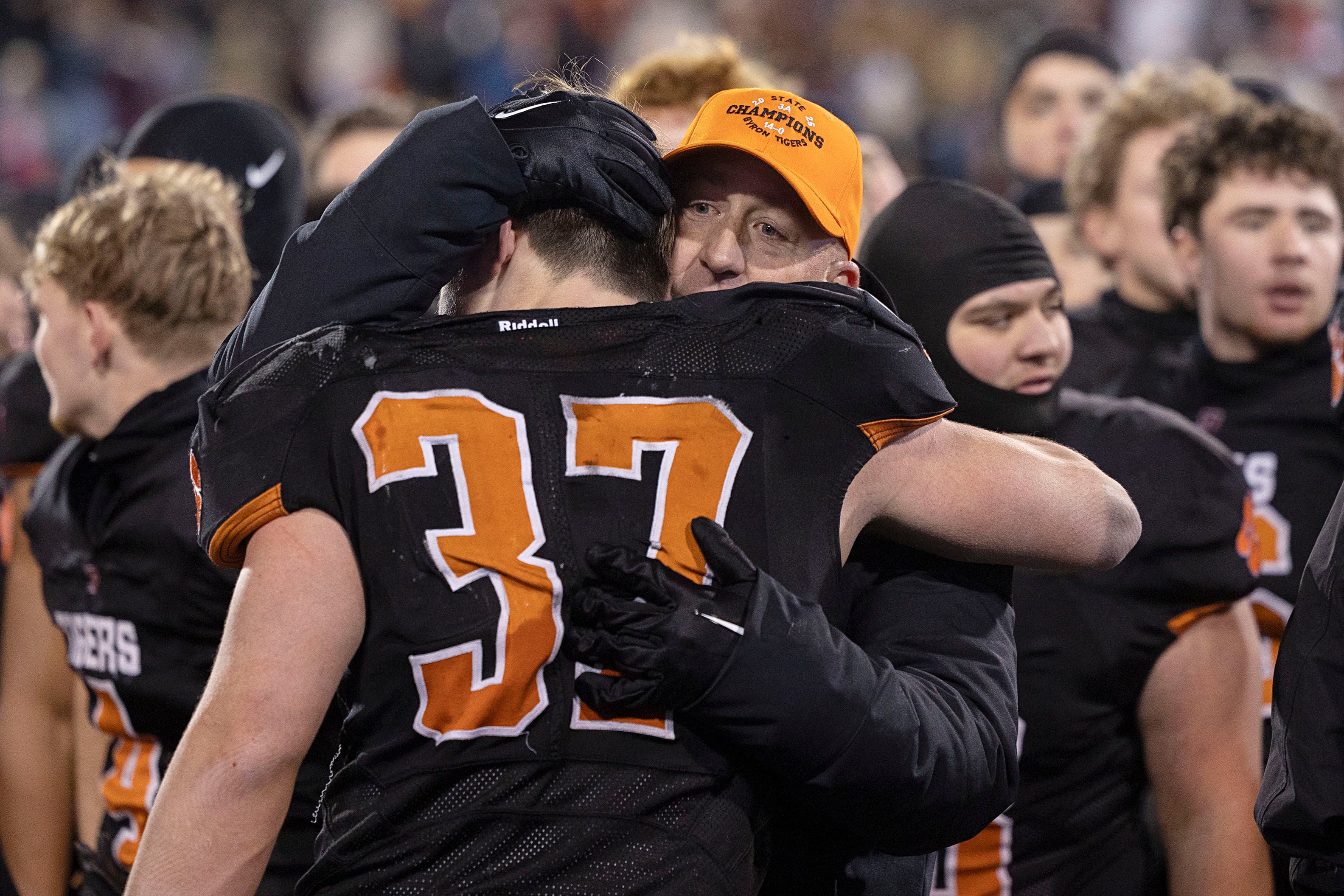 Byron head coach Jeff Boyer hugs Byron’s Caden Considine after the Tigers beat Tolono-Unity 56-50 Friday, Nov. 28, 2025, in the Class 3A football finals at Hancock Stadium at ISU.