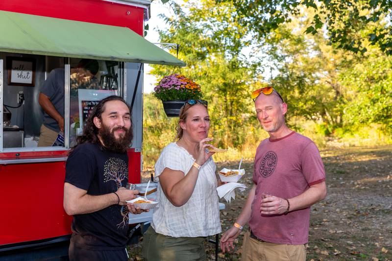 Laura Sanoyo, Nathaneal Sieder (L) and Chad Hart from Monee enjoy a meal and beer at the Brew at the Bridge event. Sept 21, 2024 in Oswego.
