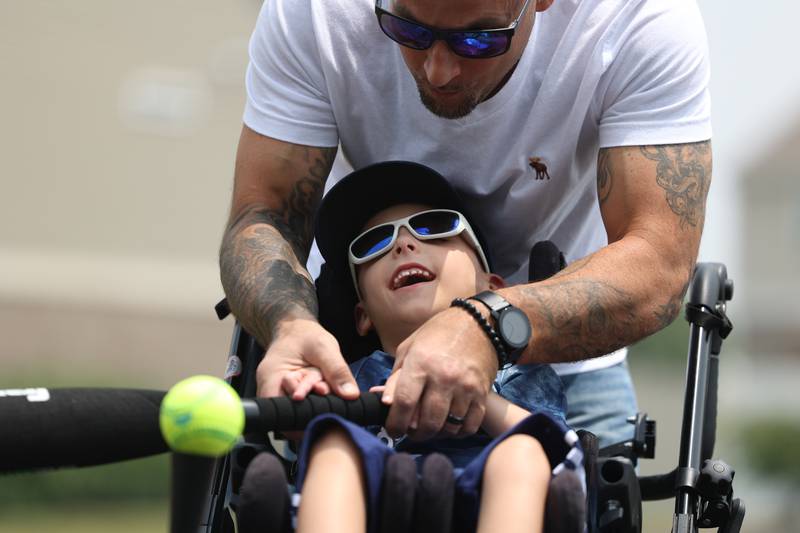 Justin Kozlowski plays tee ball with his son, Austin, in the driveway of their home in New Lenox on Wednesday, June 28th, 2023. The Kozlowski’s are working to change the Miracle League of Joliet’s policy after their son was prevented from participating in the organizations baseball league despite playing the previous two years.
