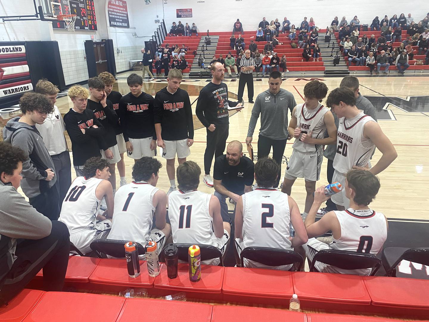 Woodland head coach Connor Kaminke (at center) talks to his Warriors during a timeout Friday, Dec. 12, 2025, at the Warrior Dome in rural Streator.