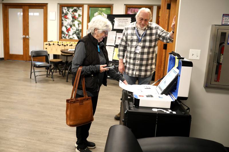 Election judge Jeff Utroska assists voter Gay Vacek of St. Charles as she votes in the 2025 Consolidated Election on Tuesday, April 1, 2025 at the Baker Community Center in St. Charles.