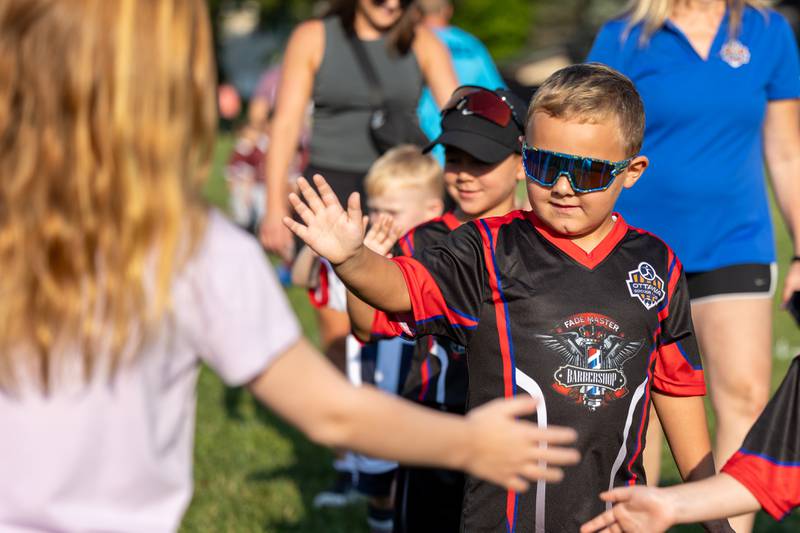 Barrett Reeve high-fives friends and family attending the opening day ceremony of youth soccer on Saturday, Aug 16, 2025, at Peck Park in Ottawa.