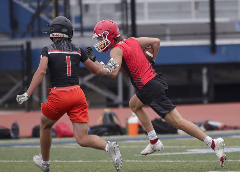 Hinsdale Central’s Carter Contreras, right, runs the ball after a catch against Minooka’s Connor Christensen during the Downers Grove South 7-on-7 in Downers Grove on Saturday, July 16, 2022.