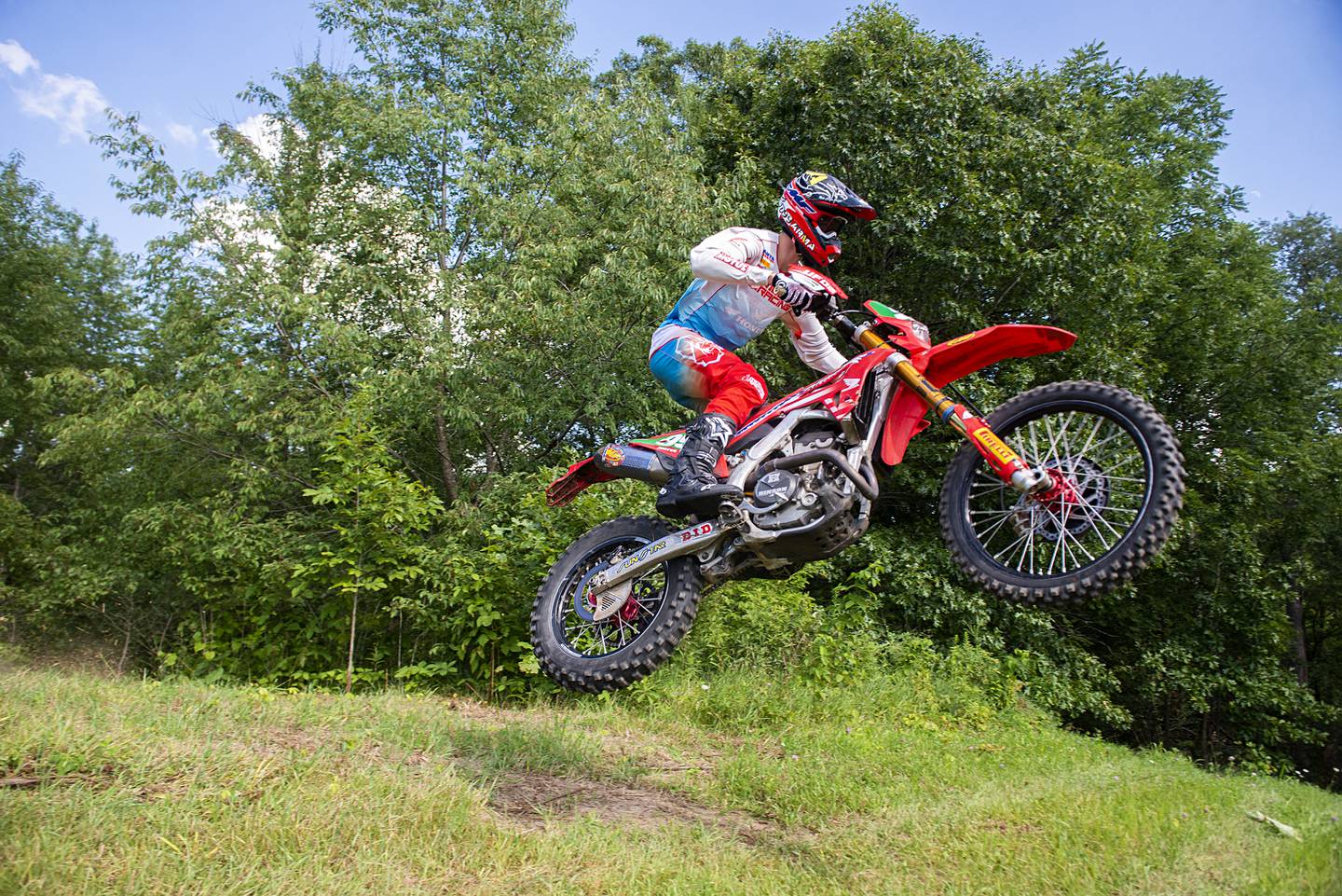 Cody Barnes soars over a hill while training on a course Thursday, August 4, 2022 near Fenton. Barnes will be traveling overseas later this month to participate in an international motocross competition.