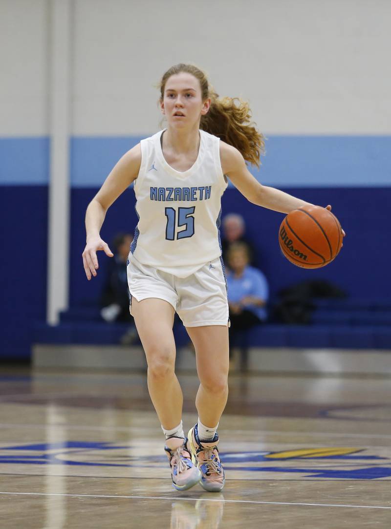 Nazareth's Mary Bridget Wilson (15) brings the ball up court during the girls varsity basketball game between Carmel High School and Nazareth Academy on Wednesday, Dec. 7, 2022 in LaGrange, IL.