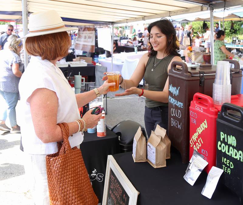 Janet Parker of Elburn gets a fresh lemonade/ice tea drink from Nely Robles of Java Plus at the Geneva French Market on Sunday, June 16, 2024.
