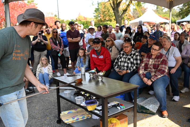 Audience members watch as Matthew Urban, who is based in Bloomington-Normal, demonstrates the making of a glass pumpkin during the Glass Pumpkin Patch event at the Morton Arboretum in Lisle on Saturday, Oct. 12, 2024.