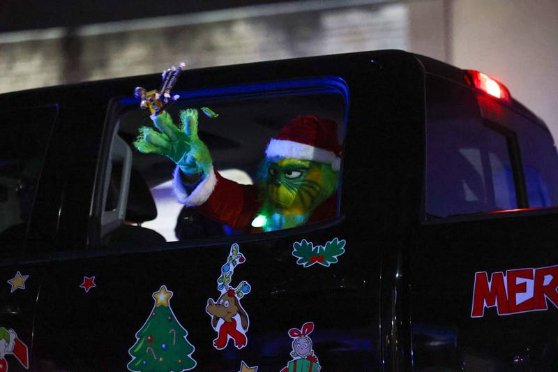 The Grinch tosses candy to the crowd during the 40th annual Bradley Christmas Parade on Friday, Dec. 5, 2025.