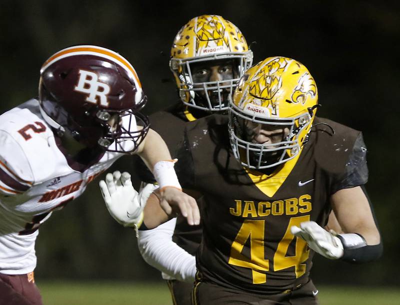 Jacobs' Antonio Brown, center, looks to run behind his teammate, Paulie Rudolph, right, as Brother Rice's Jack Morrison closes in during a IHSA Class 7A first round playoff football game Friday, Oct. 28, 2022, between Jacobs and Brother Rice at Jacobs High School in Algonquin.