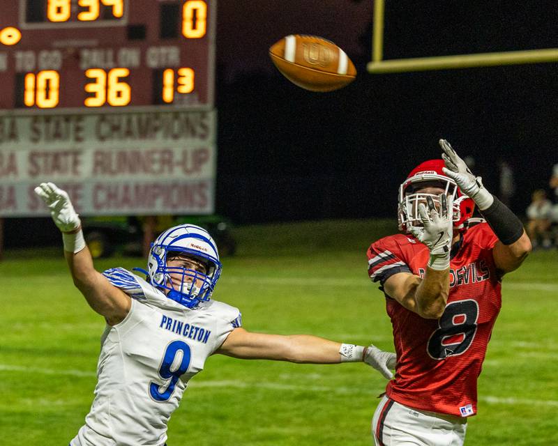 Braden Curran (8) of Hall looks to catch pass as Deacon Gutshell (9) of Princeton attempts to tackle him on Friday, Oct. 3, 2025 at Richard Nesti Stadium in Spring Valley.