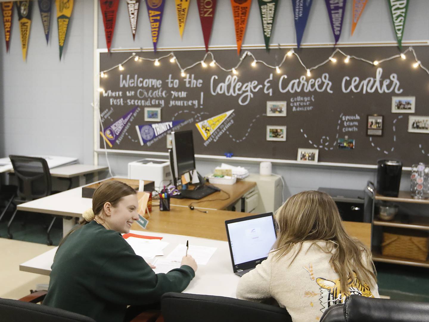 Hailey Baker, the college and career advisor at Crystal Lake South High School, helps senior Meg Norten (left) fill out a scholarship application Thursday, Jan. 26, 2023, at the school in Crystal Lake. This year's senior class is made up of students who began their high school careers dealing with COVID-19.