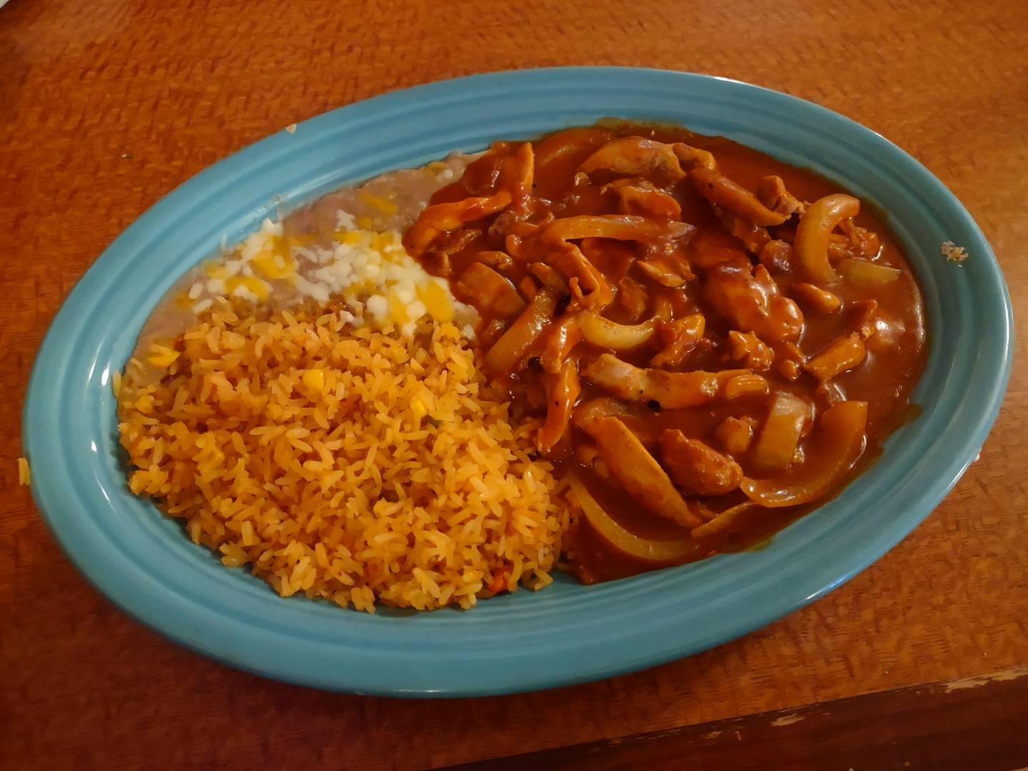 The chili Colorado with chicken at Mr. Salsas is served in red sauce with onions and a side of rice.
