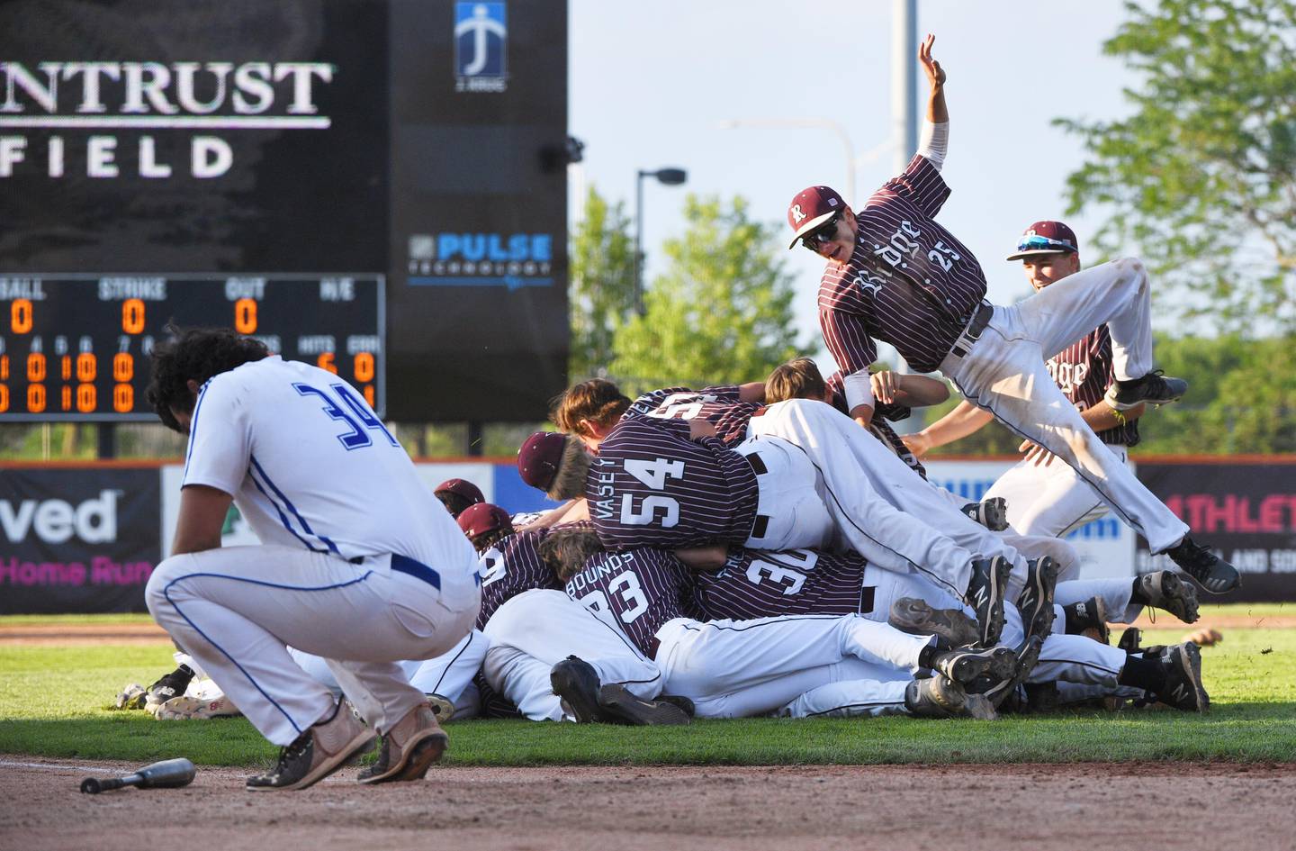 Prairie Ridge's Will Komar jumps on the celebratory pile June 14, 2021 after winning the Class 3A Schaumburg Supersectional at Wintrust Field.