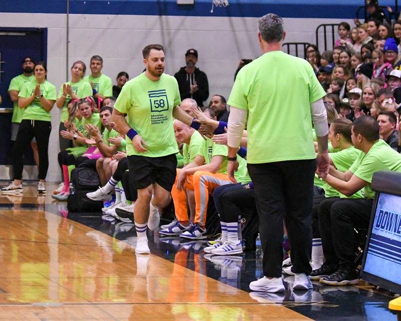 Zac Craft gets a Downers Grove staff member gets high five from the Downers Grove staff as he gets introduces at the start of the game on Sunday Jan. 19, 2025, as the staff took on the Harlem Wizards held at Downers Grove South High School.
