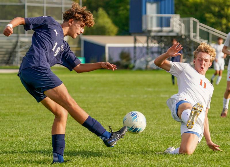 Oswego East's Aaron Godinez (18) plays the ball against Oswego’s Nolan Gustafson (11) during a soccer match at Oswego East High School on Tuesday, Sept. 26, 2023.