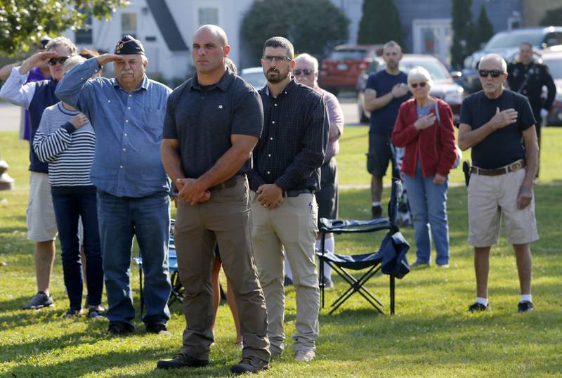 People watch as the American Flag is raised during a September 11 Remembrance Ceremony on Sept. 11, 2025, at Veterans Park in McHenry.