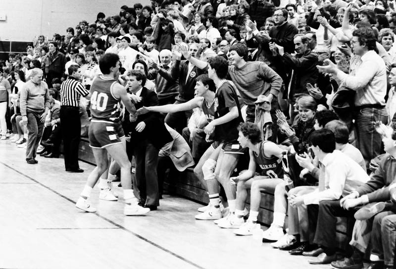 L-P's Jim Bacidore hi-fives L-P head boys basketball coach Chips Giovanine during the Regional title game on Saturday, Feb. 28, 1986 at La Salle-Peru Township High School.