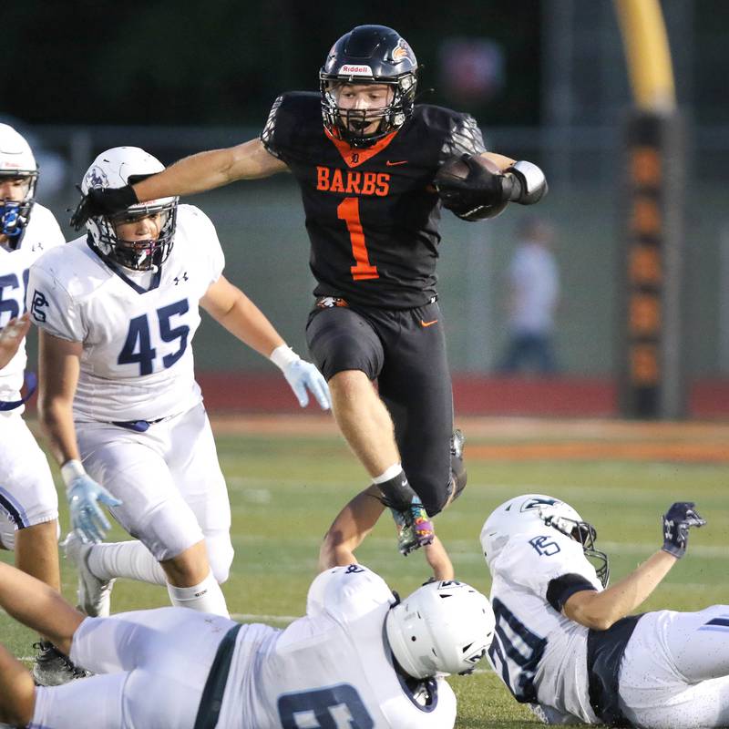 DeKalb's Talen Tate leaps two Plainfield South defenders on his way to a long touchdown during their game Friday, Sept. 1, 2023, at DeKalb High School.