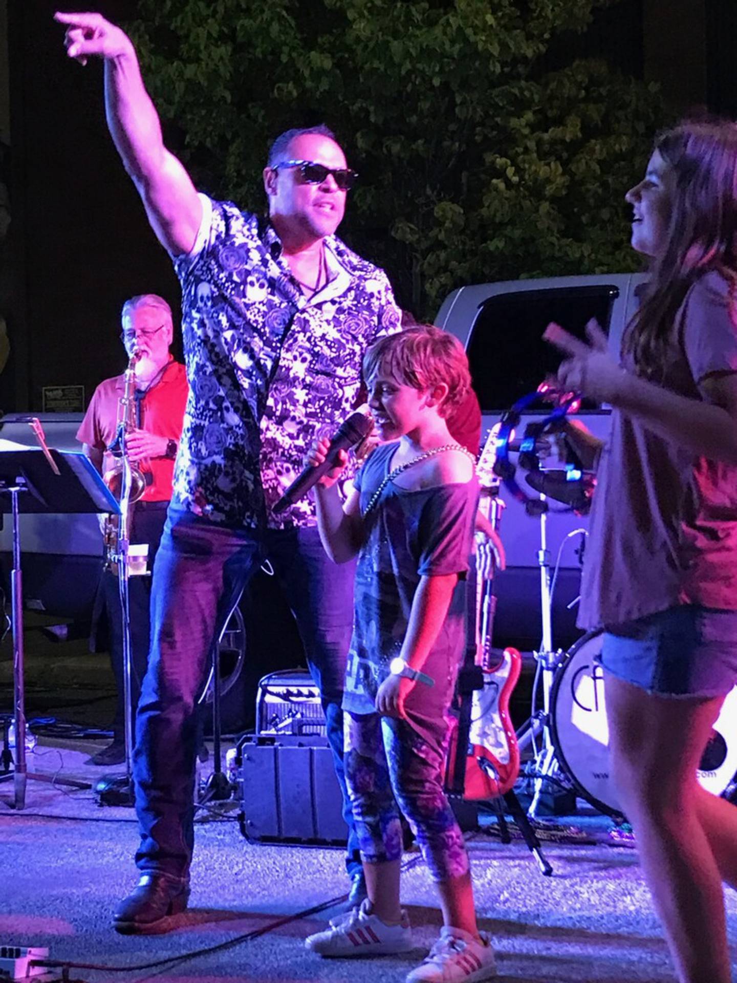 Kaelynn Johnson, 9, of Streator, sings "Uptown Funk" with Cadillac Groove lead vocalist Mike Metoyer during the final Jammin at the Clock concert of the summer Friday, Aug. 26, 2022, at Heritage Park in Streator.