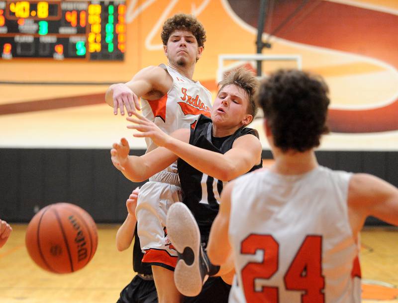 Kaneland's Troyer Carlson (10) takes a hard foul from Sandwich defender Dylan Young during a boys' basketball game at Sandwich High School on Friday, Jan. 13, 2023.