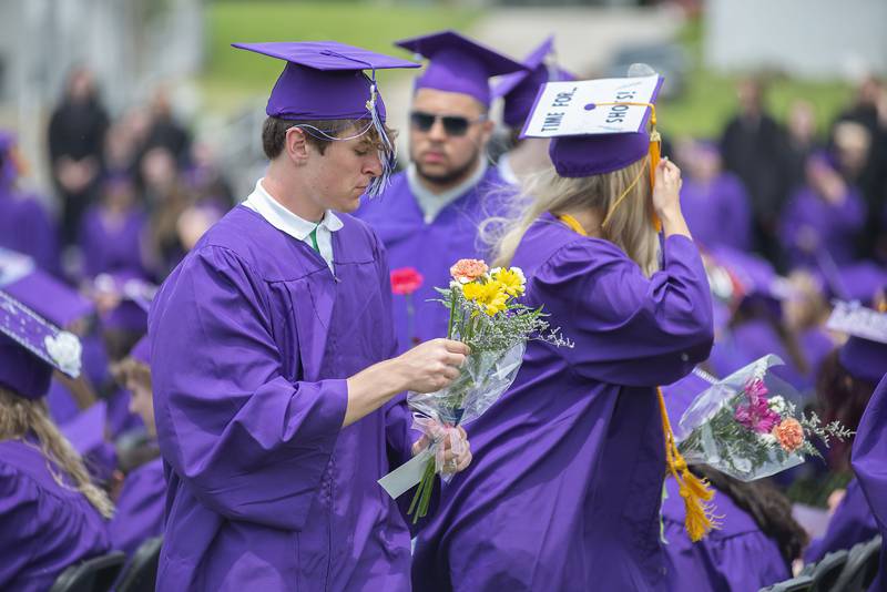 Dixon High School graduates place flowers Sunday, May 29, 2022 on empty seats for classmates who died.