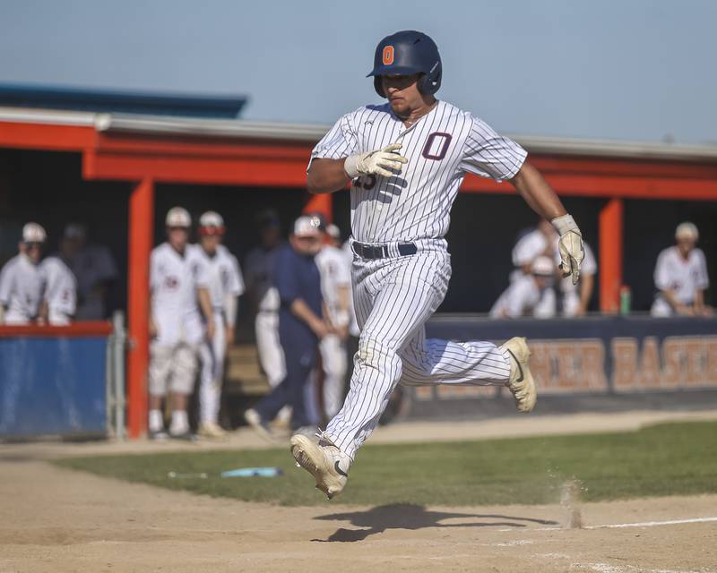 Oswego's Cam Loghmani (23) scores a run during baseball game Oswego East at Oswego.  May 14, 2026 in Oswego.