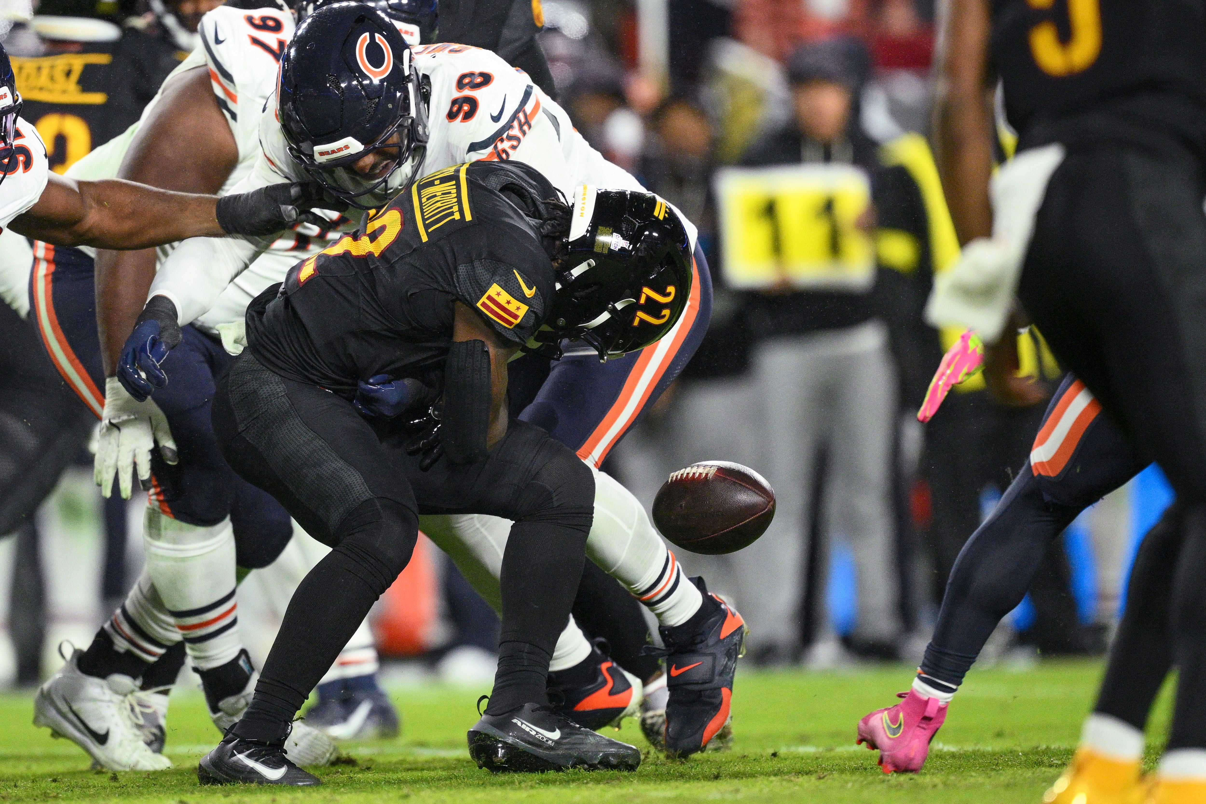 Washington Commanders running back Jacory Croskey-Merritt (22) fumbles the ball as he is hit by Chicago Bears defensive end Montez Sweat (98) during the first half of Monday's game in Landover, Maryland.