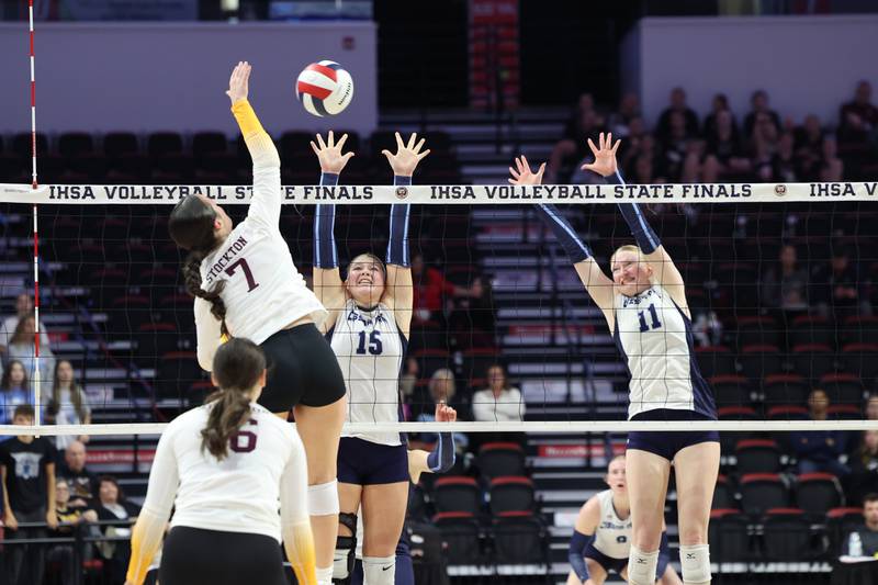 Cissna Park's Ava Henrichs, center, and Sophie Duis jump to block a hit during the Timberwolves' victory in two sets, 25-11, 25-14, over Stockton in the IHSA Class 1A State championship on Saturday, Nov. 15, 2025.