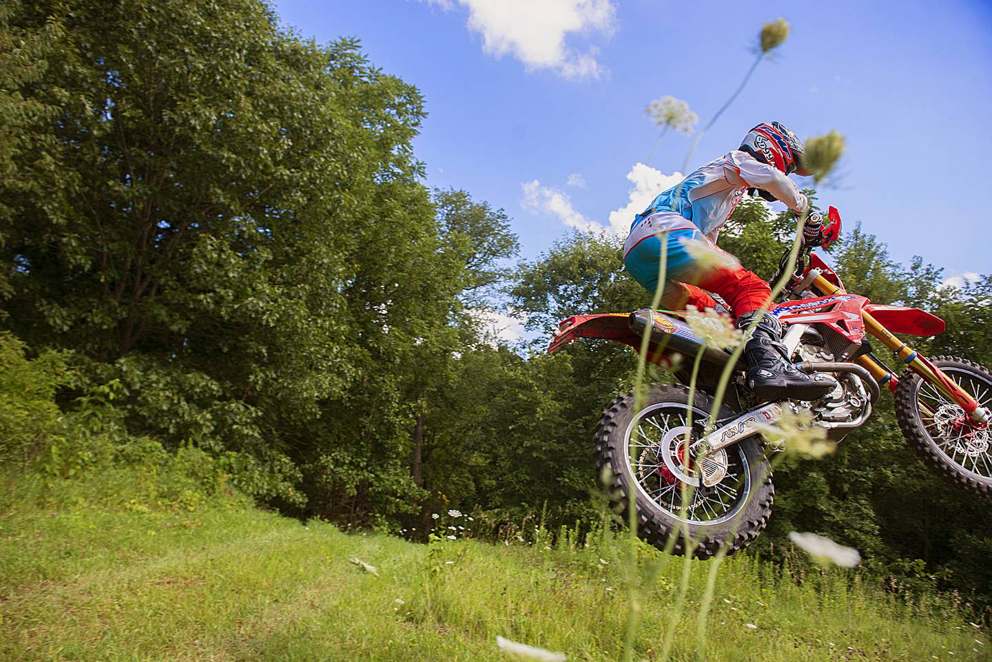 Cody Barnes of Sterling soars over a hill while training on a course Thursday, August 4, 2022 near Fenton. Barnes will be competing later this month in an international motocross competition for Team USA.