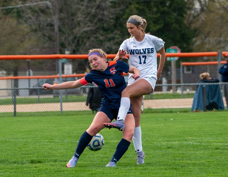 Oswego’s Elaina Hallick (11) challenges Oswego East's Erika Smiley (17) for the ball during a soccer match at Oswego High School on Monday, May 2, 2022.