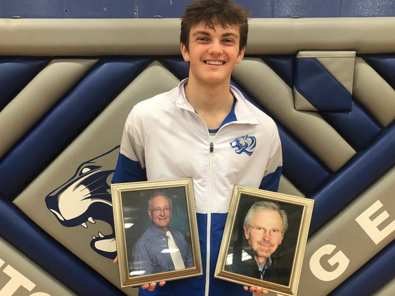 Jackson Dressler holds pictures of his late grandfathers, Joe Falk (left) and Lou Emge, who were big fans of the PHS senior and his brothers, Brandon and Jalen. The Dressler family donated money to pay for new team warmups in the grandfathers' memory.