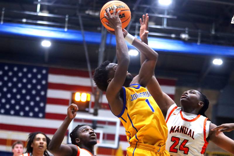 Johnsburg’s Jarrel Albea, center, works under the net against Peoria Manual in boys IHSA Class 2A Supersectional basketball on Monday, Mar. 9, 2026, at Sterling High School in Sterling.