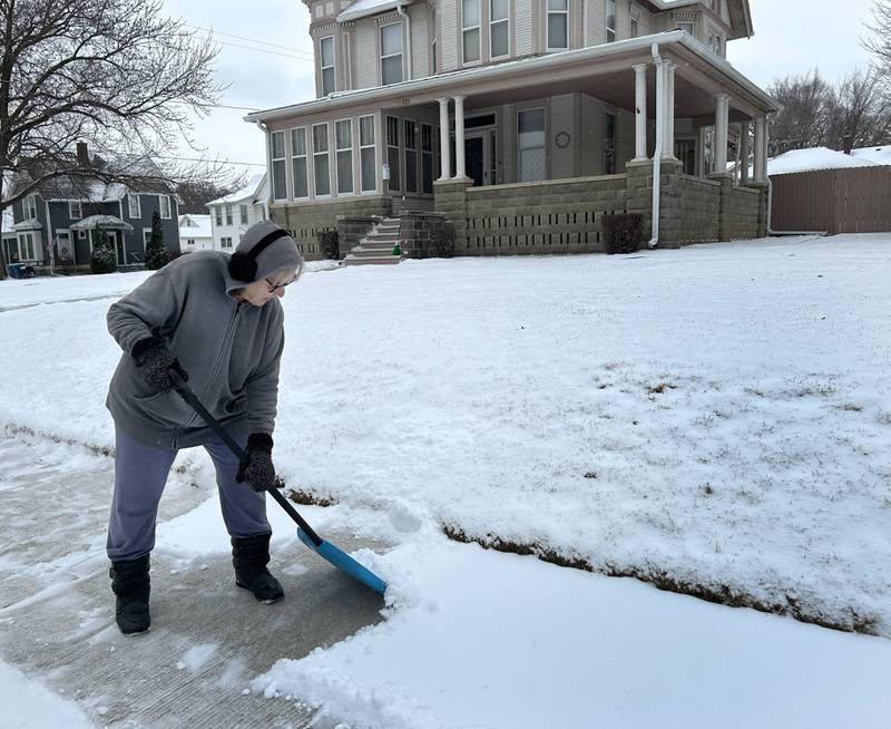 Gerrie Carter shovels snow from the sidewalk in front of her home on West Morgan Street in Dixon on Wednesday, Feb. 12, 2025. Several inches of light, fluffy snow fell across the region.