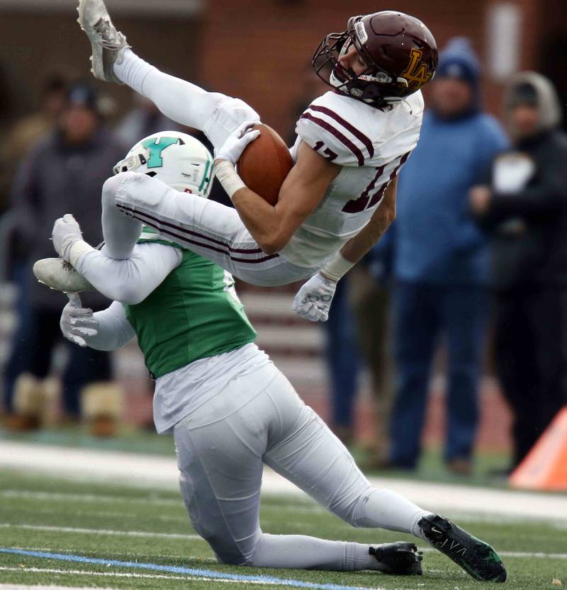 Loyola's Declan Forde (17) is upended by York’s Jacob Young (2) during the IHSA Class 8A semifinal football game Saturday November 19, 2022 in Elmhurst.
