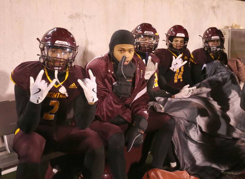 Montini Catholic players keep warm on the sidelines during the Class 3A State football championship on Friday, Nov. 29, 2024 at Hancock Stadium in Normal.