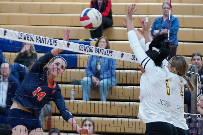 Oswego’s Mia Jurkovic (14) goes up for a kill attempt against Joliet West's Faith Jordan (6) and Lina Govoni (4) during a volleyball match at Oswego High School on Thursday, October 24, 2024.