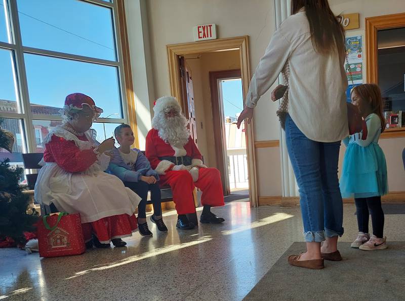 Children visit Saturday, Nov. 18, 2023, with Santa Claus and Mrs. Claus during the Christmas Walk at the Prouty Building in Princeton.