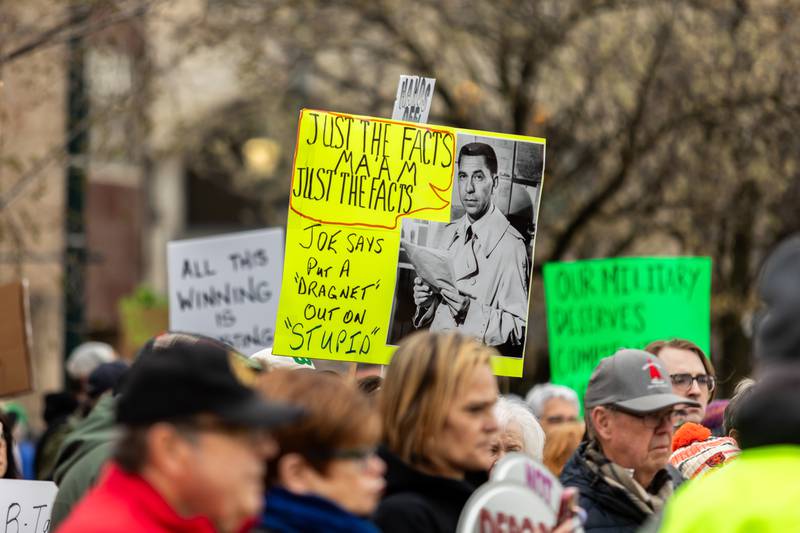 An attendee holds up a sign at the Hands Off protest in Downtown Joliet on April 5, 2025.