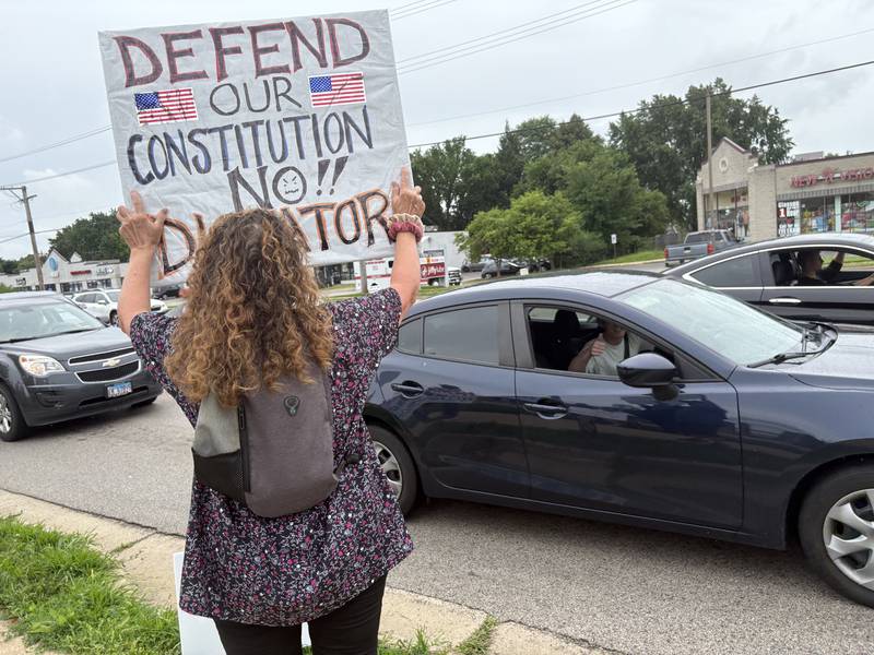 A passenger gives the "thumbs-up" during a protest against President Trump July 26, 2025 in McHenry.