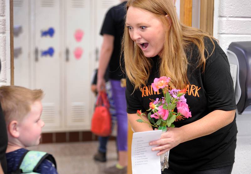 Pre-K teacher Becca Boyer is thrilled to receive flowers from student Anthony Sladek on the first day of school at Haskin Elementary in Sandwich on Wednesday, Aug. 17, 2023.