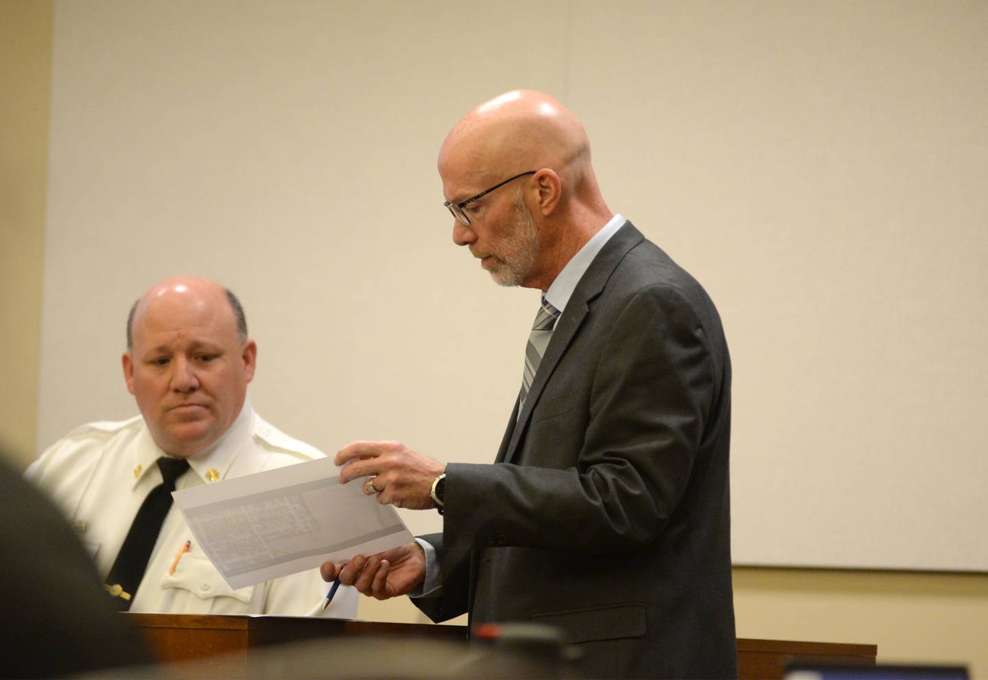 Mount Morris Fire Chief Rob Hough looks at a photo as he answers questions from Ogle County State's Attorney Mike Rock at the Ogle County Judicial Center in Oregon on Tuesday, March 19, 2024.