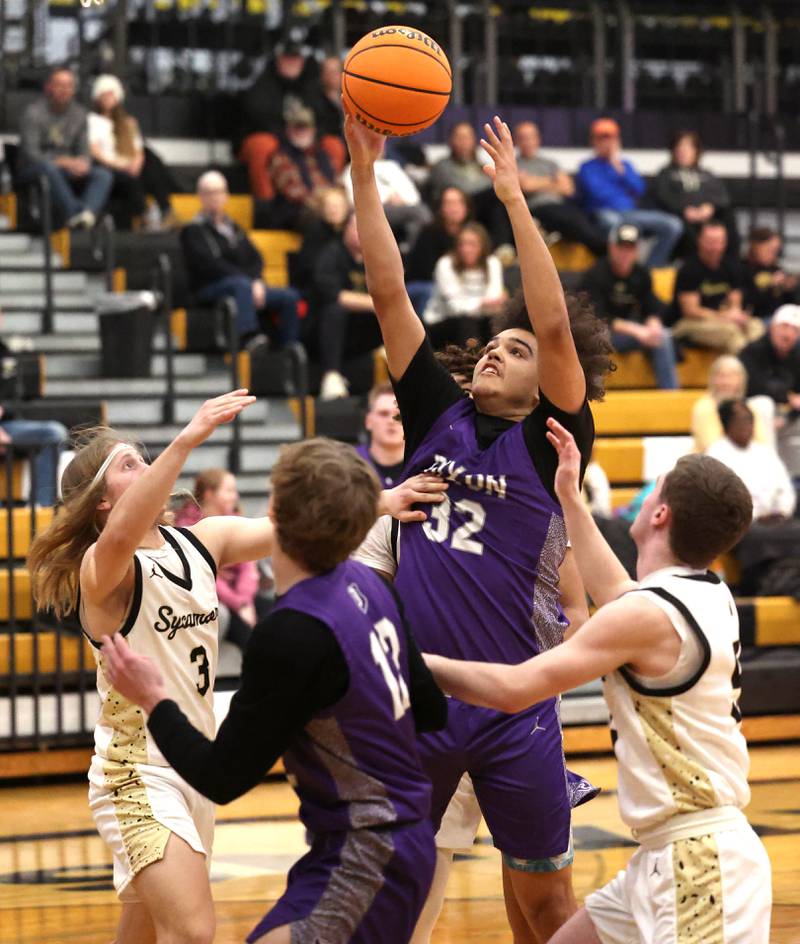 Dixon’s Darius Harrington grabs a rebound between Sycamore's Carter McCormick (right) and Preston Picolotti during their game Tuesday, Jan. 14, 2025, at Sycamore High School.