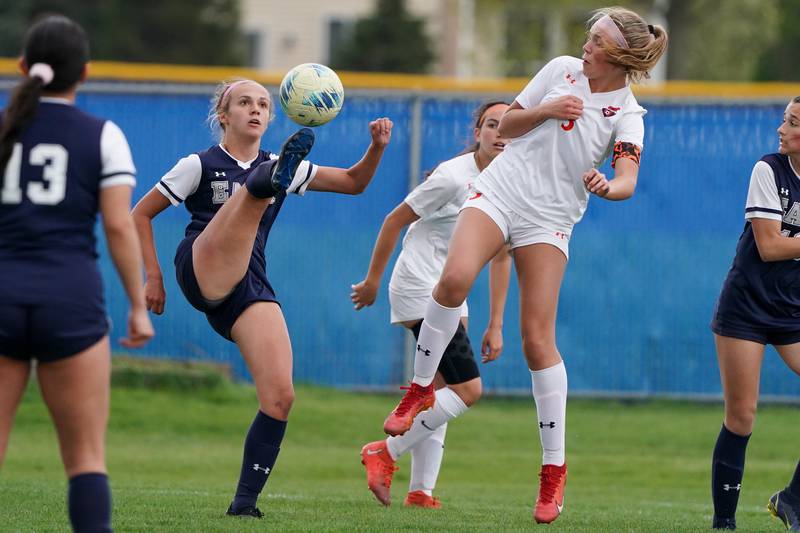 Oswego East's Anya Gulbrandsen (left) plays the ball against Oswego’s Gillian Young (right) during a soccer match at Oswego East High School on Tuesday, April 23, 2024.
