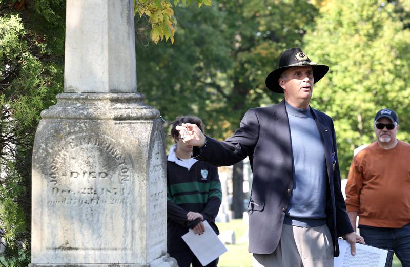 Volunteer Lars Jacobson, talks to visitors Sunday, Oct. 9, 2022, at Elmwood Cemetery in Sycamore, at the grave of James Harrington, who was an early doctor, during the Etched in Stone cemetery walk. The event, hosted by the DeKalb County History Center, told the stories of some local individuals who are buried there.