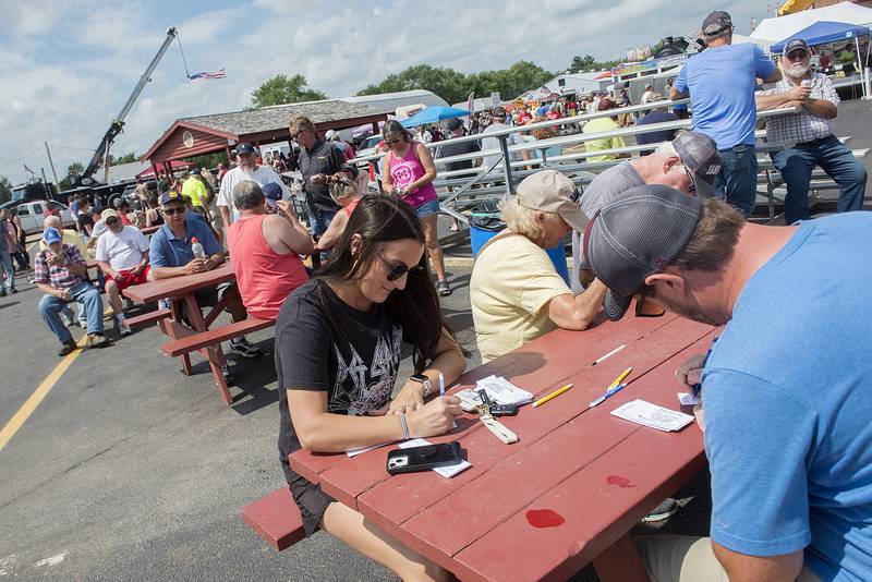 Newlyweds Kaitlin and Jordan Crane of Lasalle fill out their Amboy Depot Days 50/50 raffle tickets Sunday, Aug. 28, 2022 during the annual car show.