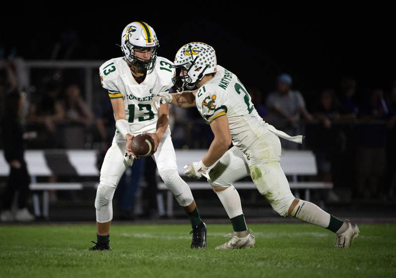 Coal City's Connor Henline hands the ball off to Logan Natyshok in a game against Manteno on Friday, October 3, 2025.