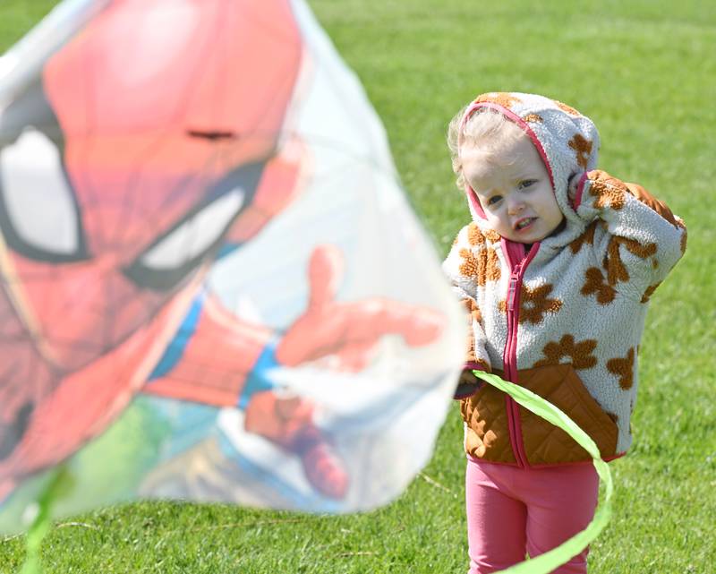 Charlotte Soto, 2-1/2, of Wheaton waits for her mom, Rachel, to get her Spiderman kite airborne during the “Go Fly a Kite” event at Graf Park on Saturday, May 3, 2025 in Wheaton.