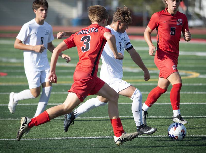 Minooka's Ethan Koranda, center, looks for a shot on goal as Bradley-Bourbonnias' Alek Perkins defends in a game on Tuesday, August 26, 2025.